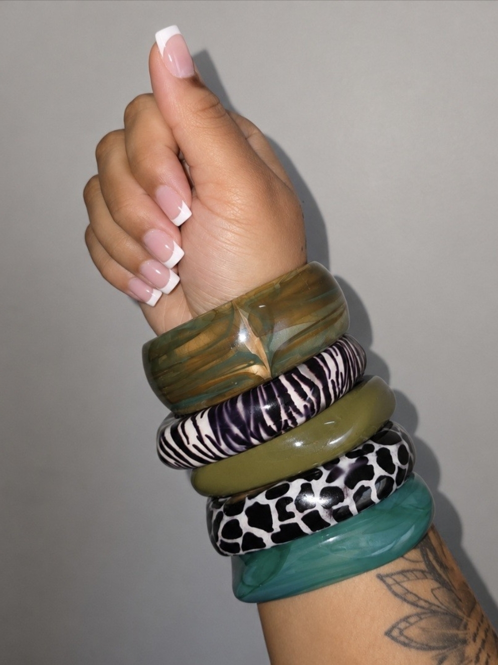 Stack of Women's Green and Patterned Resin Bangle Bracelets